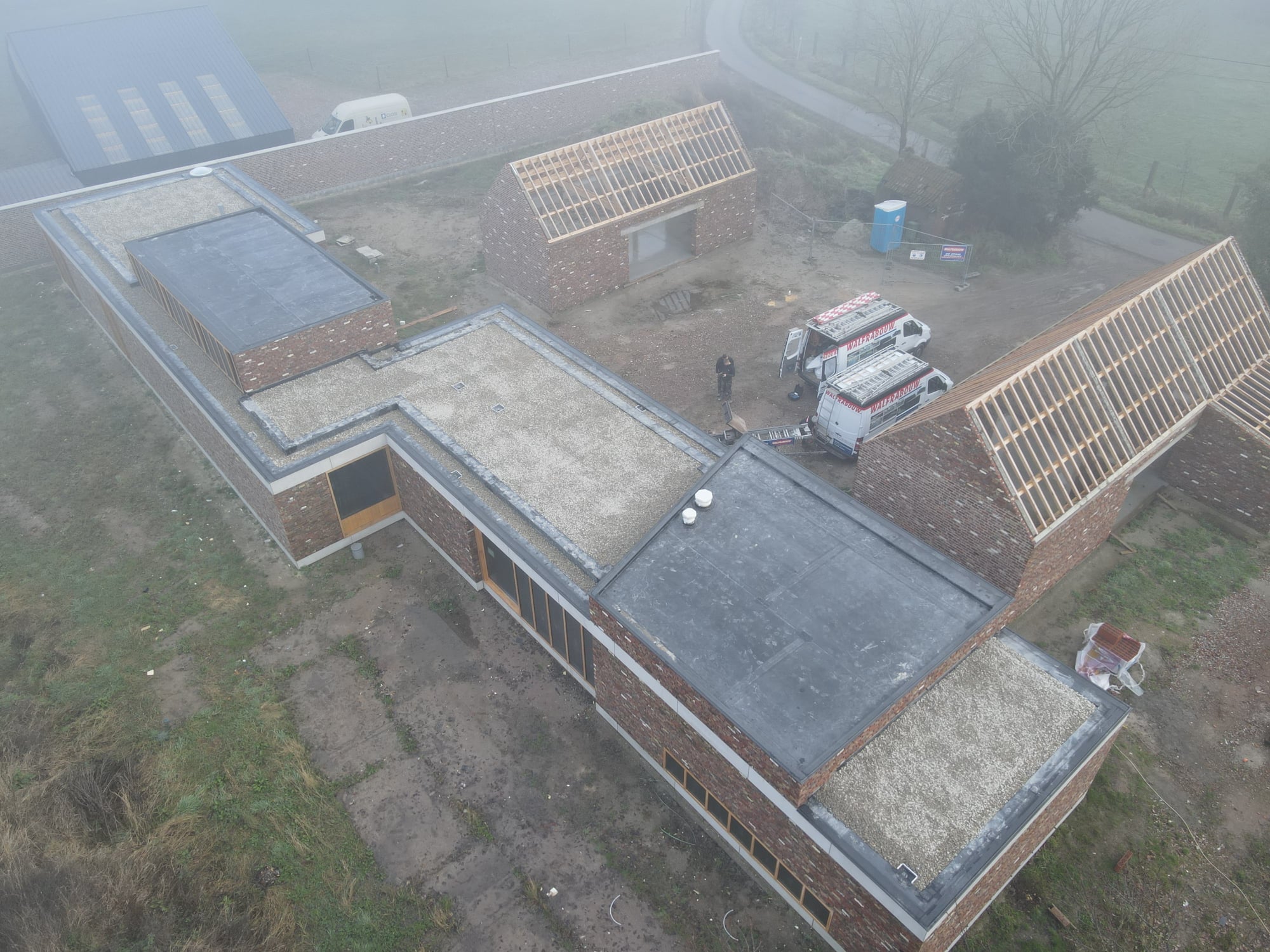 Dronebeeld van een gerealiseerd plat EPDM-dak op een moderne woning met kiezelafwerking