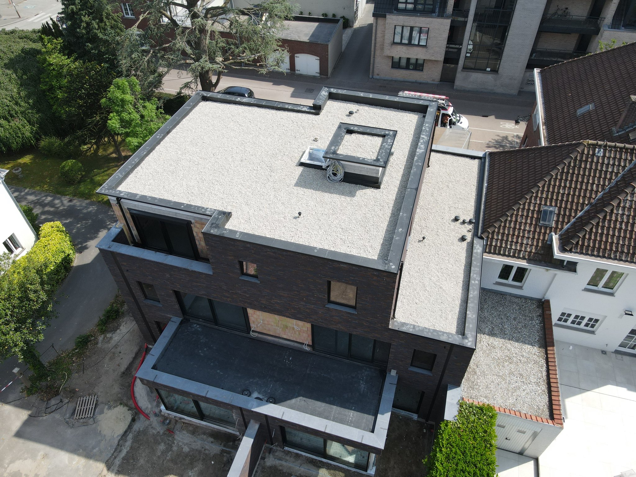Dronebeeld van een omvangrijk plat dakproject in EPDM met kiezelafwerking