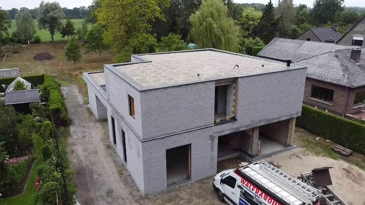 Luchtfoto van een afgewerkt plat EPDM-dak op een moderne woning met nette dakranden