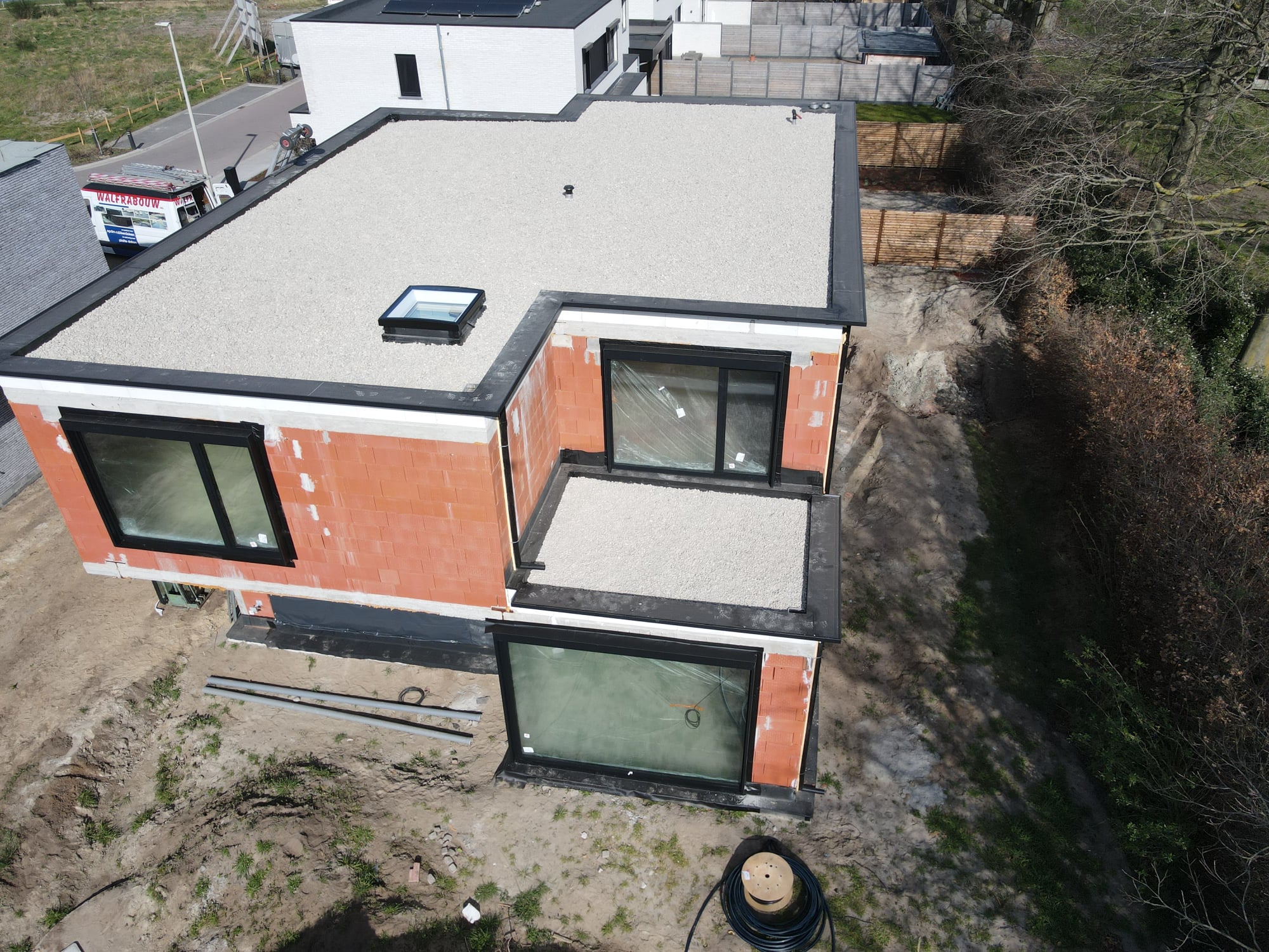 Luchtfoto van een woning met meerdere platte daken in EPDM en kiezel in een verkaveling