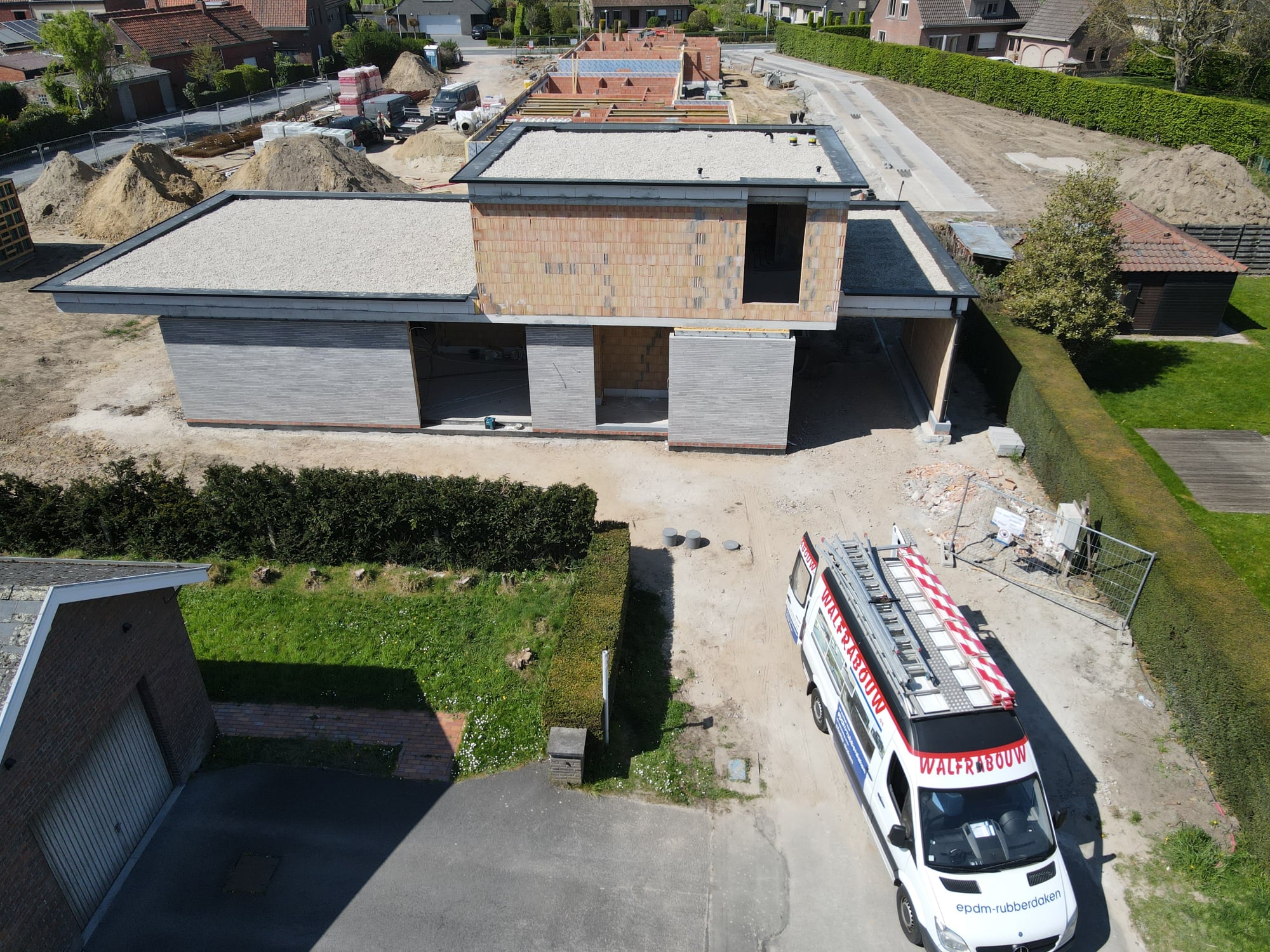 Dronebeeld van een EPDM-nieuwbouwproject met meerdere platte dakvlakken in kiezel