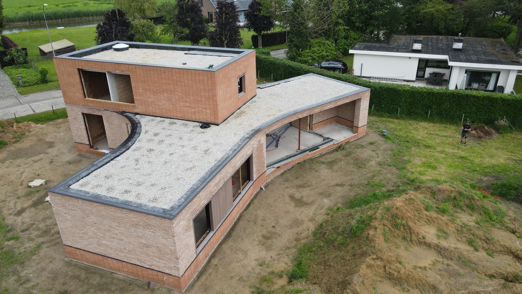 Dronebeeld van een EPDM-nieuwbouwwoning in Deinze met meerdere platte daken in wit kiezel