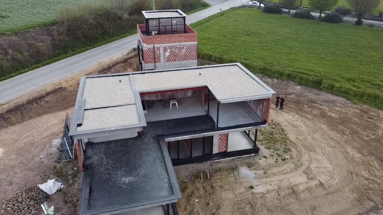 Dronebeeld van een moderne nieuwbouwwoning met afgewerkt plat EPDM- en kiezeldak