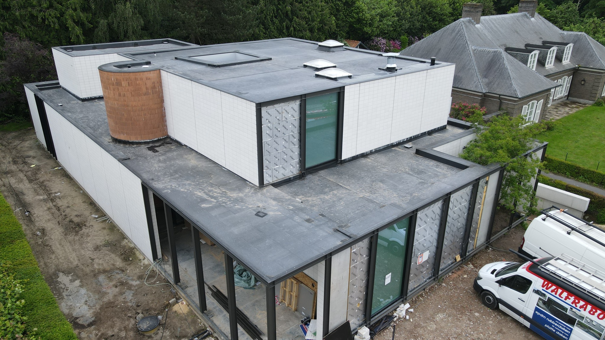 Luchtfoto van de EPDM-nieuwbouwwoning in Oostkamp met plat kiezeldak in aanbouw